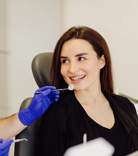 A dental professional examining a patient’s teeth during a routine checkup.